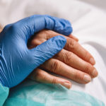 Healthcare provider holding patients hand